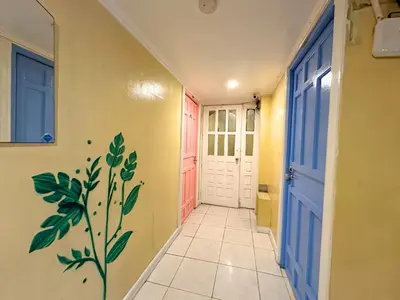a hallway with a door with a painting on the wall at Dormitelsph UST in Manila