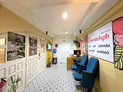 a waiting room with chairs and a sign on the wall at Dormitelsph UST in Manila
