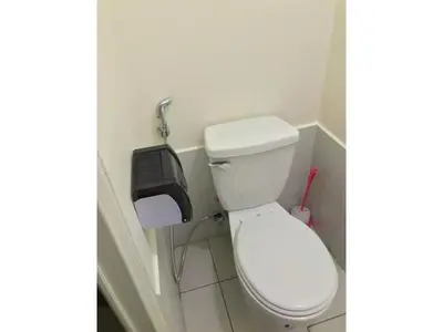 a bathroom with a white toilet and a paper dispenser at Shanilyn Residency Urban Deca Towers EDSA Mandaluyong,UNLIMITED INTERNET AND NETFLIX in Manila