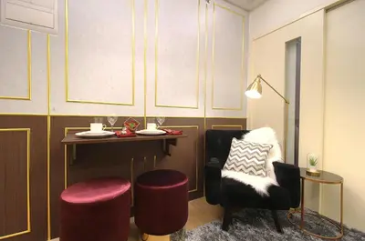a dining room with a table and a chair at Makati - Chino Roces Trevi Towers in Manila