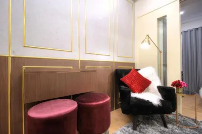 a living room with a chair and two stools at Makati - Chino Roces Trevi Towers in Manila