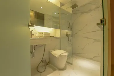 a bathroom with a shower and a toilet and a sink at Red Hotel Cubao, Quezon City in Manila