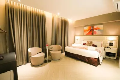 a bedroom with a bed and a table and chairs at Red Hotel Cubao, Quezon City in Manila
