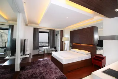 a hotel room with a bed and a television at Malate Bayview Mansion city view in Manila