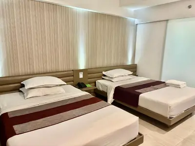 a hotel room with two beds and a window at The E-Hotel Makati in Manila
