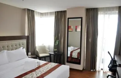a hotel room with a bed and a mirror at ACE Hotel and Suites in Manila