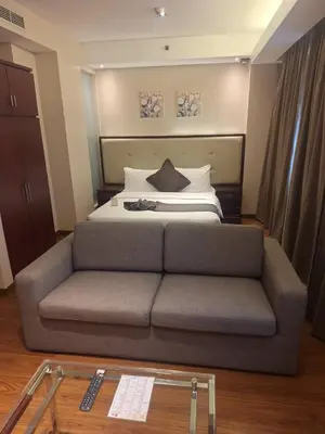 a bedroom with a bed with a couch in front of it at ACE Hotel and Suites in Manila
