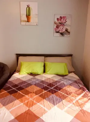 a bedroom with a bed with a multicolored blanket at Studio Fully Furnished in Manila