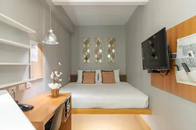 a small room with a bed and a television at Selah Pods Hotel Manila in Manila