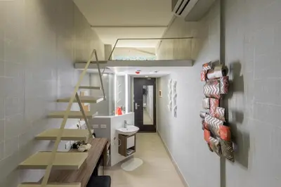 a bathroom with a staircase and a toilet in a room at Selah Pods Hotel Manila in Manila