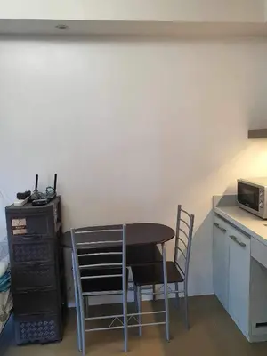 a kitchen with a table and chairs and a microwave at A Home with a view, 1 Bdrm with balcony and Netflix Access in Manila