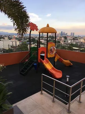 a childrens playground with slides and a carousel at A Home with a view, 1 Bdrm with balcony and Netflix Access in Manila