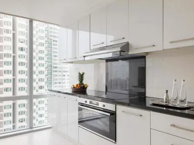 a kitchen with white cabinets and a large window at Raffles Makati in Manila