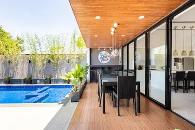 a dining room with a table and a swimming pool at Addie's Place Soldiers Hills Village Muntinlupa in Manila