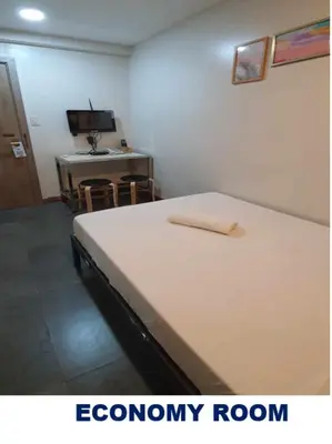 a room with a bed and a desk with a television at Maine City Residences in Manila
