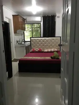 a bedroom with a bed in a room with a window at Bing's Place in Manila