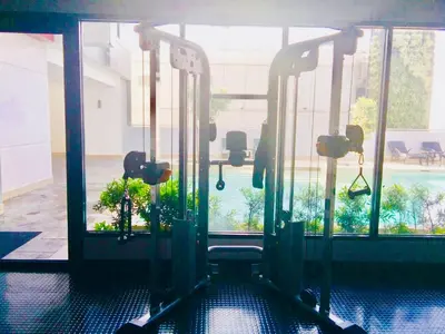 an empty gym with a view of a pool at The Sentinel Residences Suite in Manila