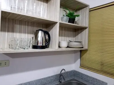 a tea kettle on a shelf above a kitchen sink at Super Cute Hampton Suites in Imus