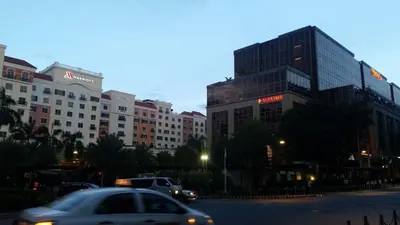 a car driving down a city street with tall buildings at F-10C Parkside Villas in Manila