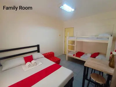 a bedroom with a bed and two bunk beds at Bed and Brewhouse Sucat in Manila