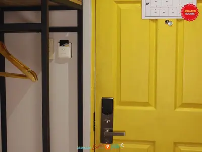a yellow door with a sign on the wall at Citizen Hotel in Manila