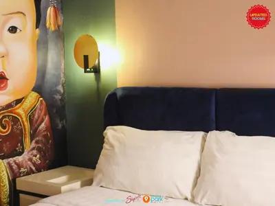a bedroom with a bed with a large face on the wall at Citizen Hotel in Manila