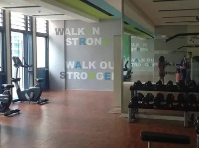 a gym with a wall with the words walk in storm walk out streege at Affordable Cozy Pad in Salcedo Village Makati in Manila