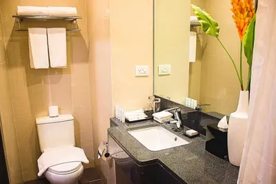 a bathroom with a toilet and a sink and a mirror at Hotel Lucky Chinatown Binondo Manila in Manila
