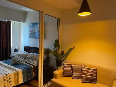 a bedroom with a mirror and a bed at Great 1BR Aqua Livingstone with Netflix, Pool & Gym in Manila