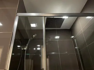 a shower with a glass door in a bathroom at Great 1BR Aqua Livingstone with Netflix, Pool & Gym in Manila