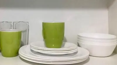 a group of plates and cups on a counter at Ameer Condotel @ Parkside Villa in Manila