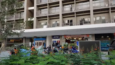 an apartment building with people on motorcycles in front of it at 1 Bedroom Apartment @SMDC Shore Residences, Mall of Asia in Manila