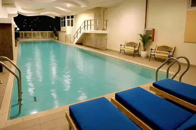 a large swimming pool with blue water in a building at JMM Grand Suites in Manila
