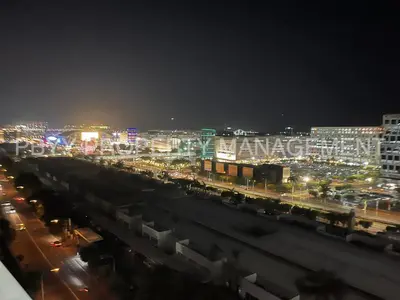 a city lit up at night with buildings and cars at Shore Residences, Mall Of Asia Complex Stays by PBYY in Manila