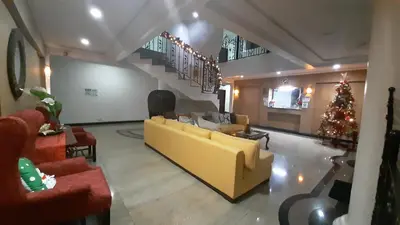 a living room with a yellow couch and a christmas tree at Casa Micarosa Hotel in Manila
