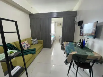 a living room with a couch and a table at Green Residences Stays by PBYY in Manila