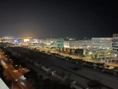 a city lit up at night with cars and buildings at Shore Residences, Mall Of Asia Complex Stayction by PBYY in Manila