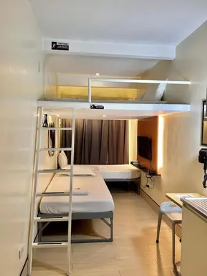 a room with two bunk beds and a desk at Selah Lofts Hotel in Manila