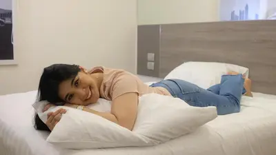 a young woman laying on a bed with pillows at Red Planet BGC The Fort in Manila
