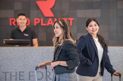 two women standing next to each other with luggage at Red Planet BGC The Fort in Manila