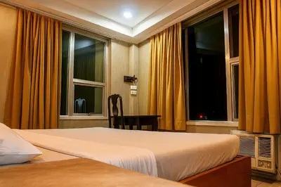 a bedroom with a bed and two windows at CONNECTOR Hostel in Manila