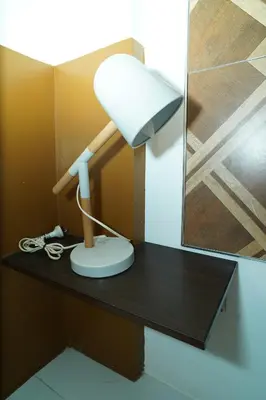 a lamp sitting on a desk with a mirror at ROCCA Del GARDA Residences in Binangonan