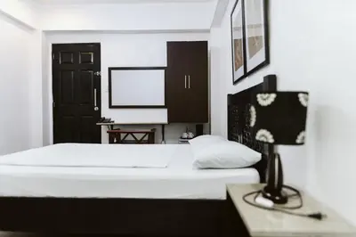 a bedroom with a bed and a desk with a lamp at San Agustin Residences in Manila