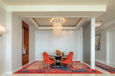 a dining room with a table and chairs and a chandelier at Solaire Resort Entertainment City in Manila