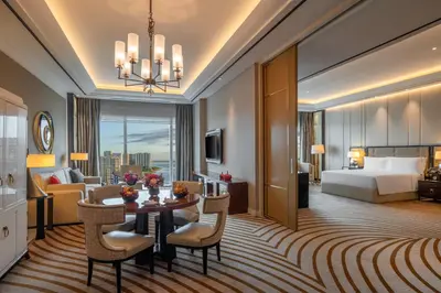 a hotel room with a bed and a table and chairs at Solaire Resort Entertainment City in Manila