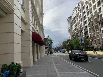 a car driving down a city street with buildings at Modern and Cozy Studio near Airport Terminal 3 in Manila