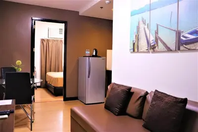 a living room with a couch and a refrigerator at The Studio 18 Residences in Manila