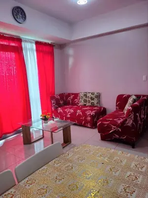 a living room with a red couch and a glass table at Cubao ManhattanHeights Unit 7EF Tower B, 1BR in Manila