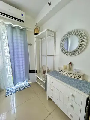 a bathroom with a mirror and a dresser at Santiorini at Shore Residences in Manila