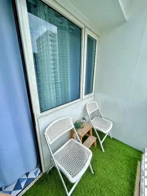 a balcony with two chairs and a table and a window at Santiorini at Shore Residences in Manila